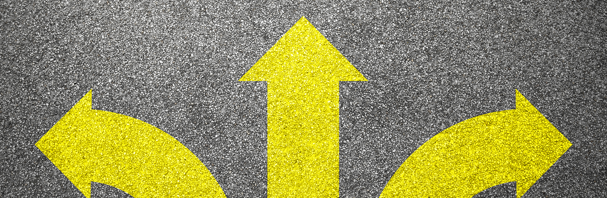 Three yellow arrows: one pointing left, one going straight, and one pointing right, on a black surface.