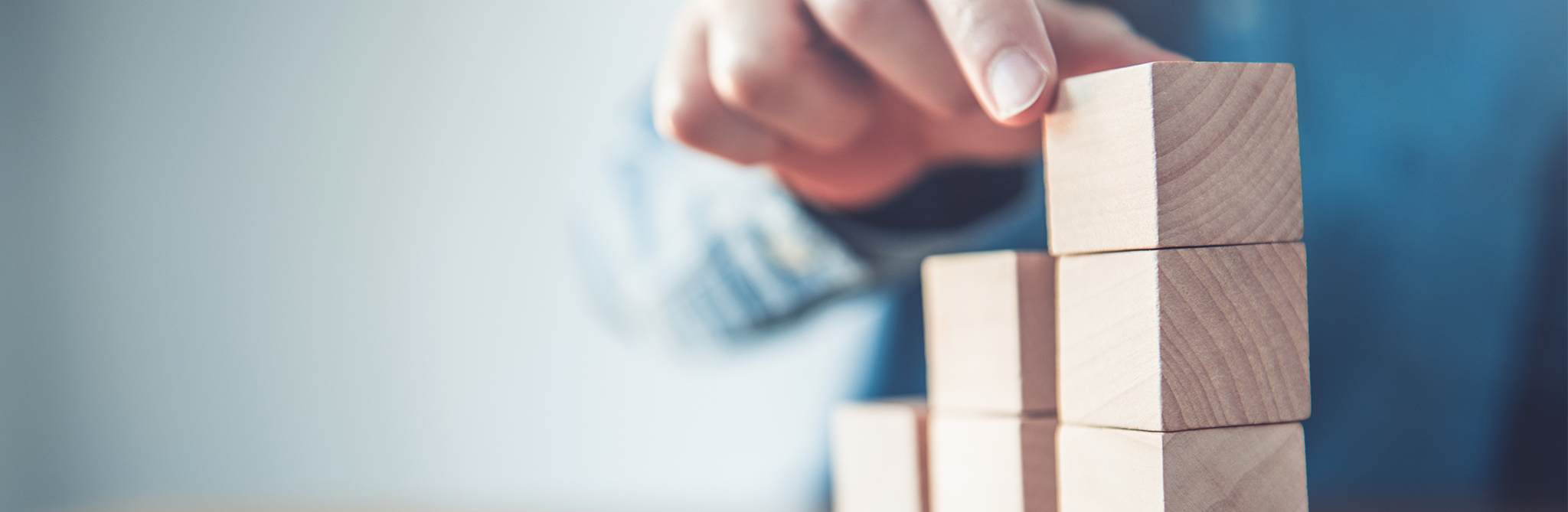 A person stacking wooden blocks.
