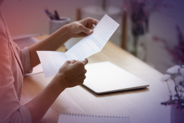 Close up young woman holding paper letter with good news.