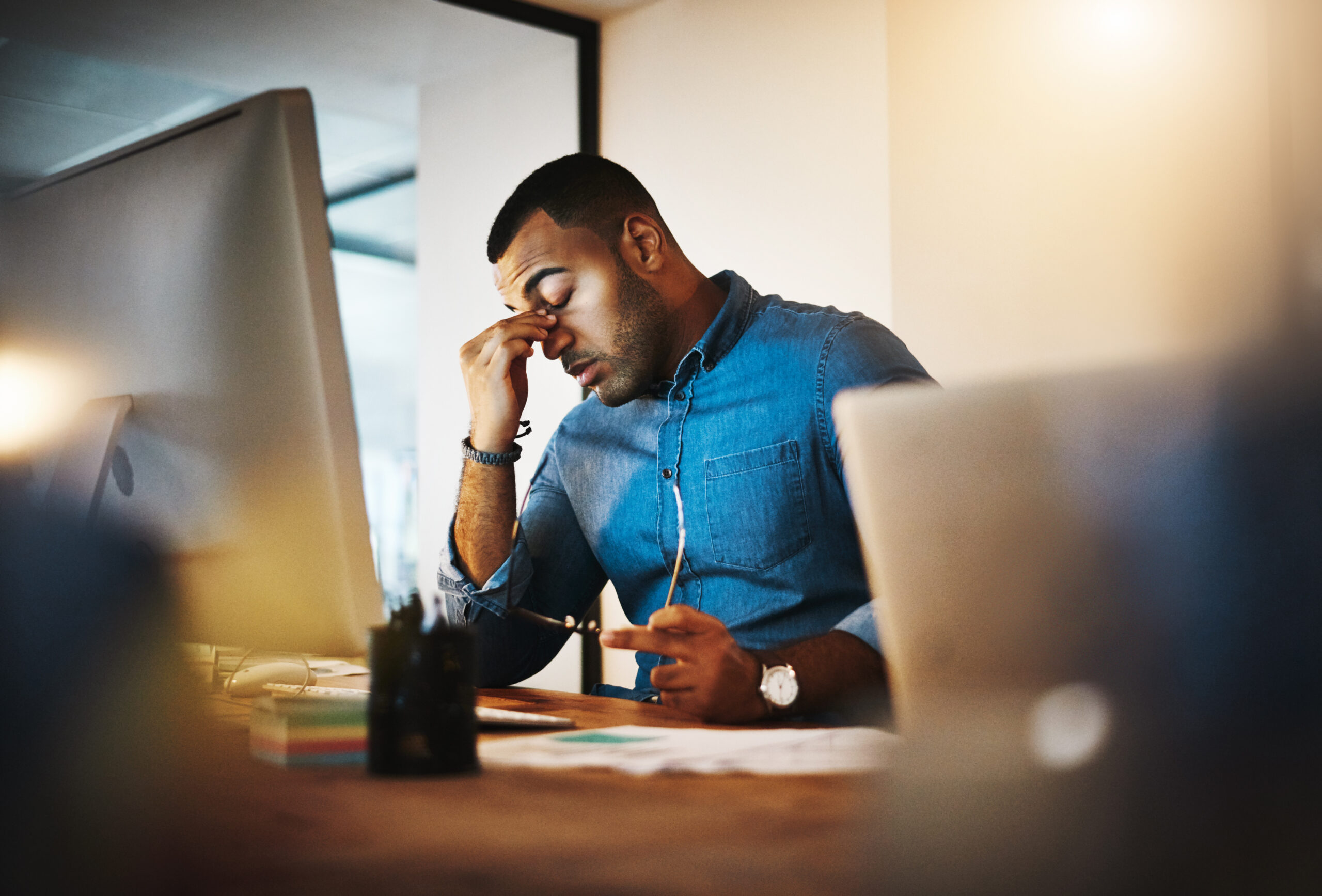 Headache, tired and businessman working in the office with eye strain from the computer or technology. Burnout, migraine and professional male employee doing research on a desktop in the workplace.