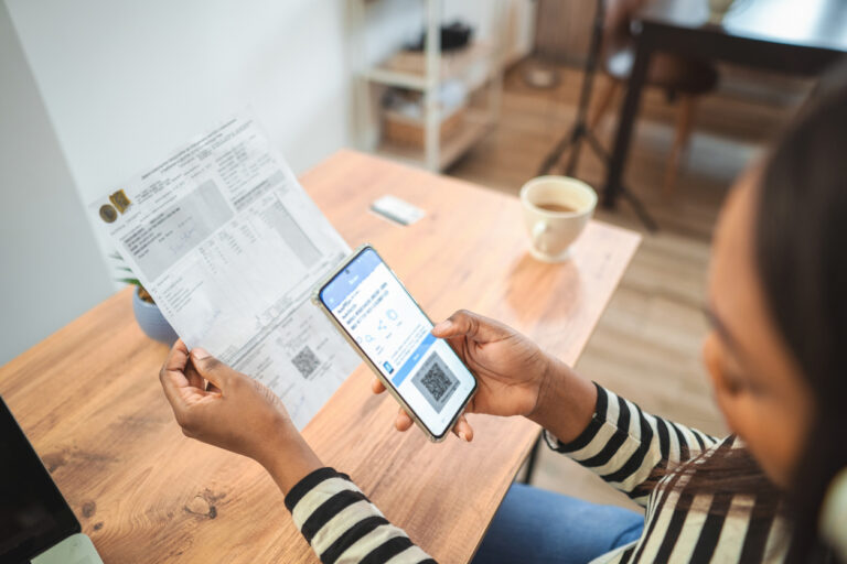 Woman is paying bills using mobile banking application on smartphone